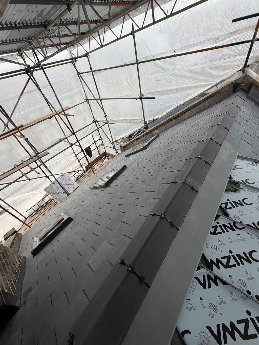 Slate pitch with roof windows, finished against zinc